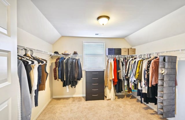 spacious closet featuring lofted ceiling and light carpet