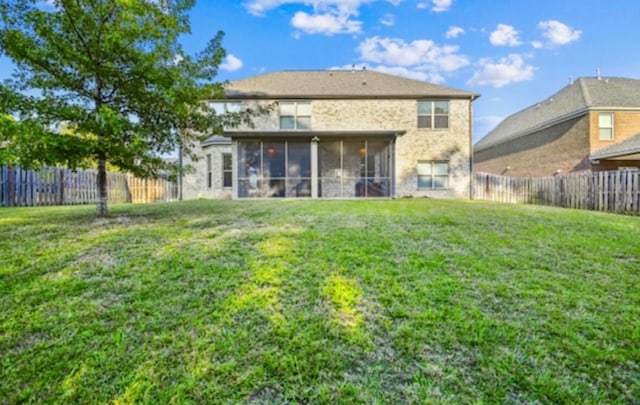 back of house with a sunroom and a yard