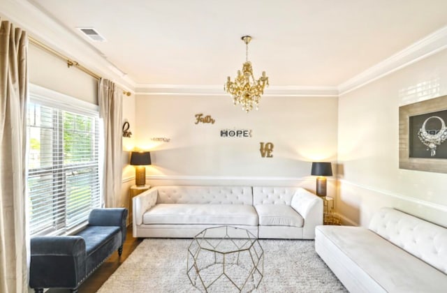 living room featuring crown molding, light hardwood / wood-style floors, and an inviting chandelier