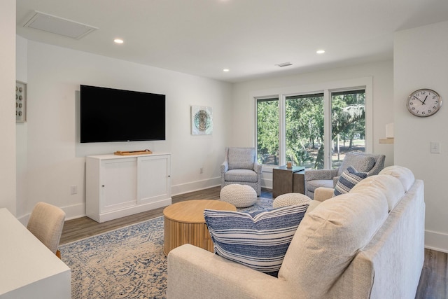 living room with recessed lighting, baseboards, visible vents, and wood finished floors