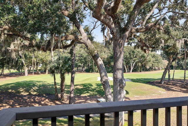 view of yard featuring view of golf course and a balcony