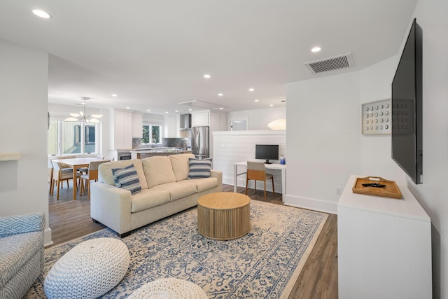 living area with recessed lighting, wood finished floors, and visible vents