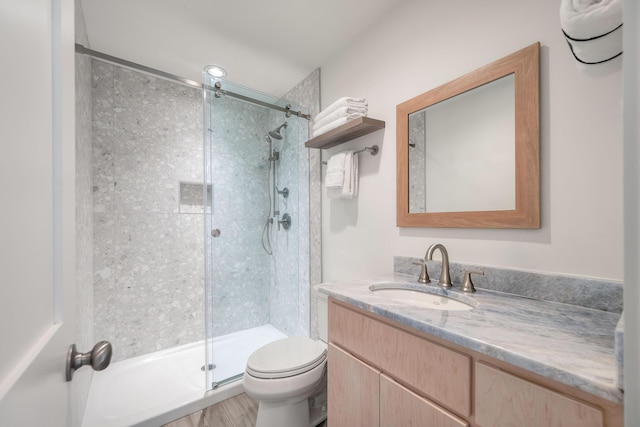 bathroom featuring vanity, a stall shower, and toilet