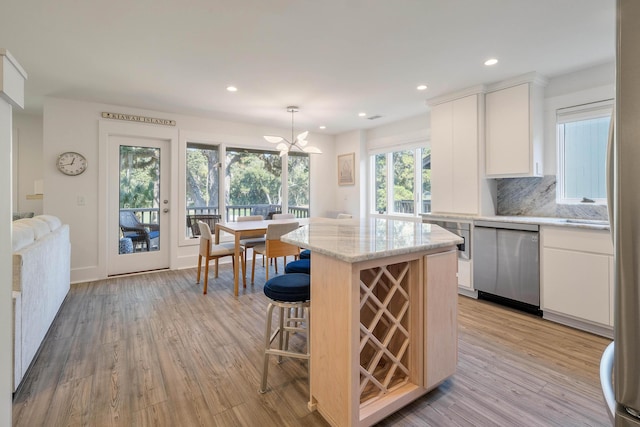 kitchen with stainless steel dishwasher, light wood-style floors, recessed lighting, a center island, and white cabinetry