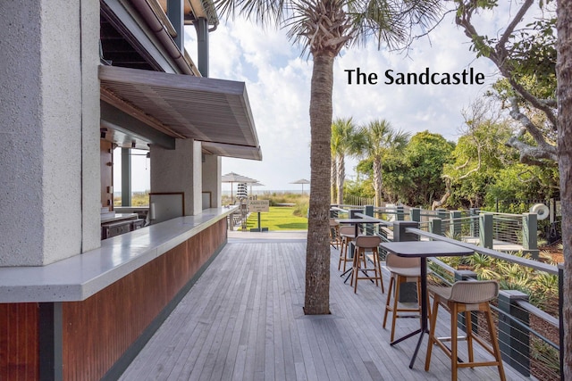 wooden terrace featuring outdoor dining space and outdoor dry bar