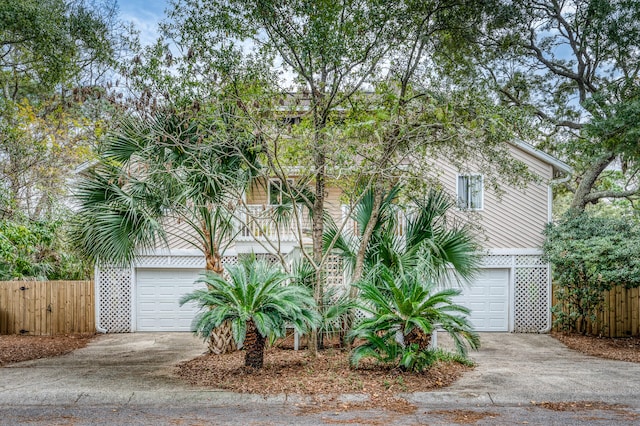 view of property hidden behind natural elements featuring a garage