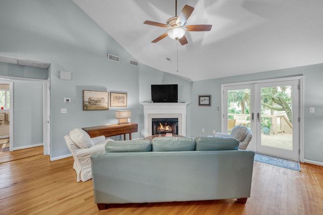 living room featuring ceiling fan, light hardwood / wood-style flooring, high vaulted ceiling, and a healthy amount of sunlight