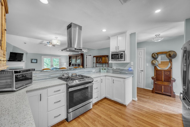 kitchen with white cabinets, ceiling fan, light hardwood / wood-style floors, island range hood, and stainless steel appliances