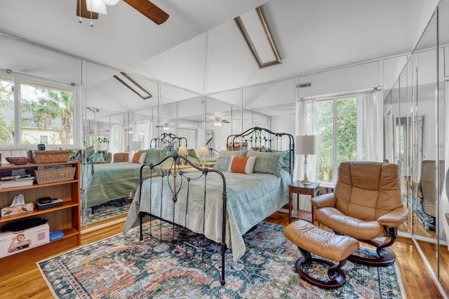 bedroom with light hardwood / wood-style flooring, multiple windows, lofted ceiling, and ceiling fan