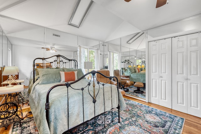 bedroom featuring hardwood / wood-style floors, a closet, ceiling fan, and lofted ceiling