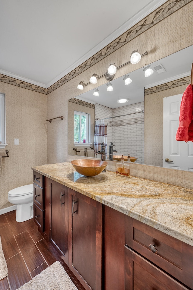 bathroom featuring a shower with shower curtain, vanity, toilet, and crown molding