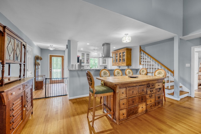 kitchen featuring ventilation hood, light hardwood / wood-style floors, and kitchen peninsula