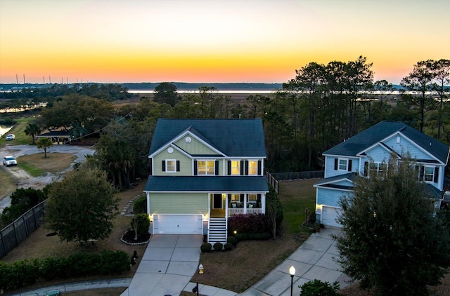 traditional-style home with concrete driveway, fence, a garage, and roof with shingles