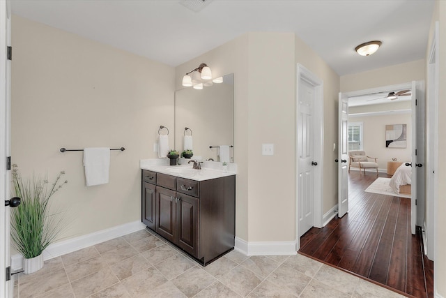 ensuite bathroom featuring visible vents, connected bathroom, baseboards, wood finished floors, and vanity