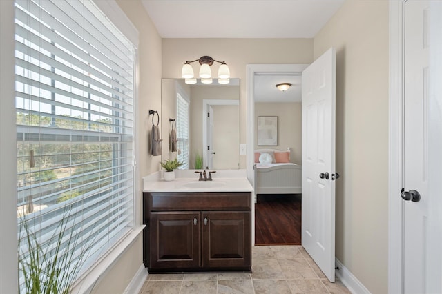 bathroom with vanity, baseboards, a chandelier, and connected bathroom