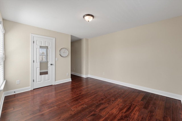 unfurnished room featuring dark wood-style floors and baseboards