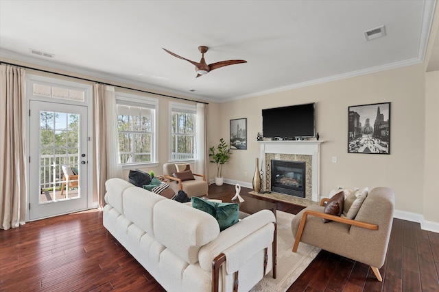 living area featuring dark wood finished floors, crown molding, visible vents, and ceiling fan