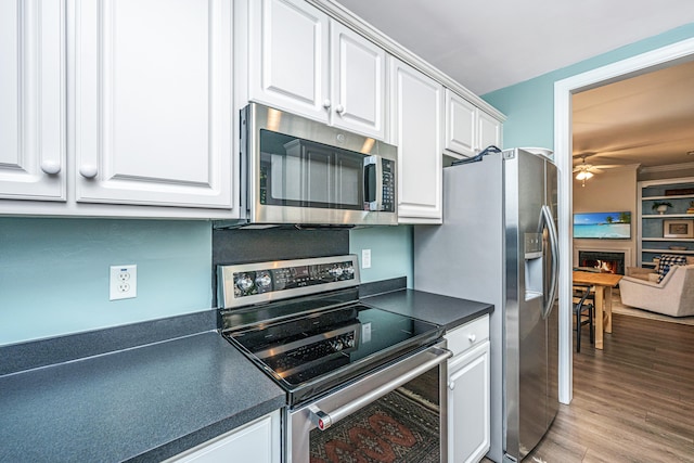 kitchen with white cabinetry, appliances with stainless steel finishes, ceiling fan, and light hardwood / wood-style floors