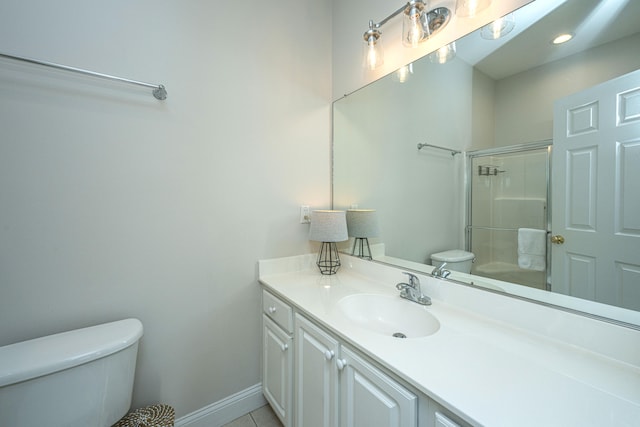 bathroom featuring tile patterned floors, vanity, a shower with shower door, and toilet