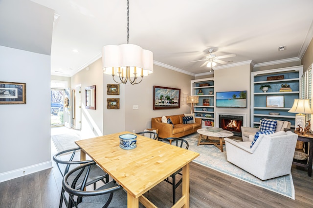 dining area with dark hardwood / wood-style floors, crown molding, and ceiling fan with notable chandelier