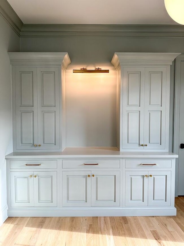 interior details featuring wood-type flooring and ornamental molding