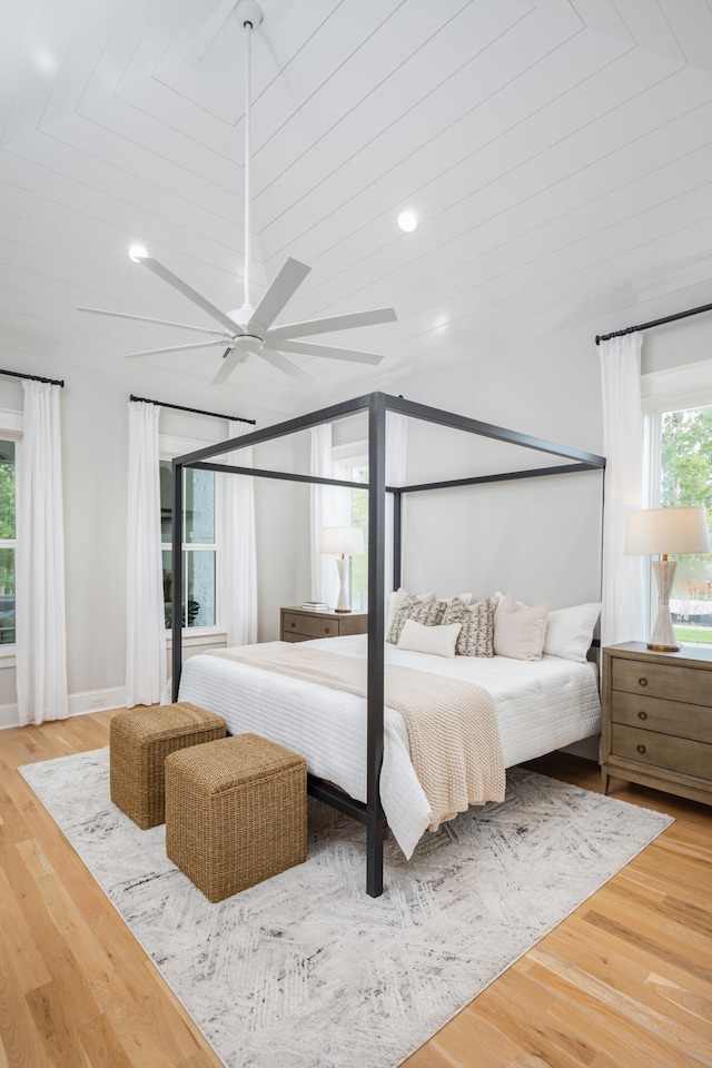 bedroom with hardwood / wood-style flooring, multiple windows, and ceiling fan