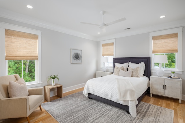 bedroom with ceiling fan, crown molding, and light hardwood / wood-style flooring