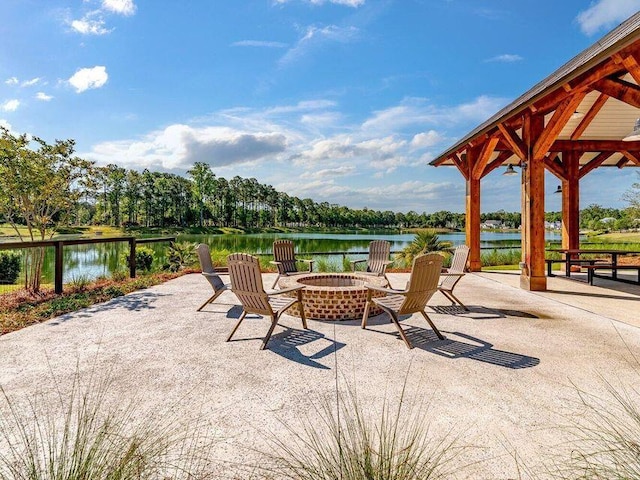 view of patio featuring a gazebo, a water view, and an outdoor fire pit