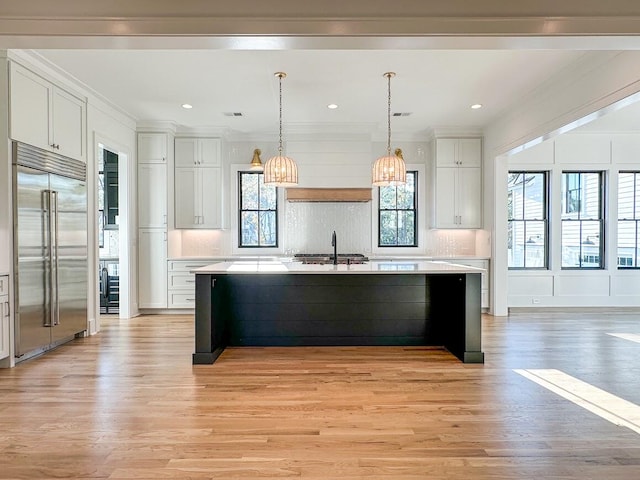 kitchen featuring a large island, white cabinetry, light hardwood / wood-style flooring, and built in refrigerator