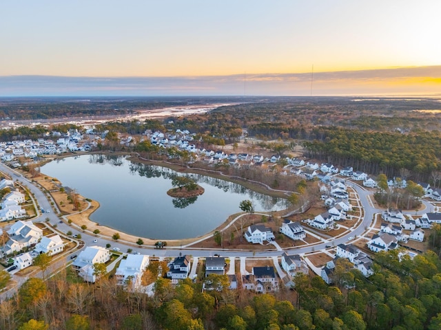 aerial view at dusk featuring a water view