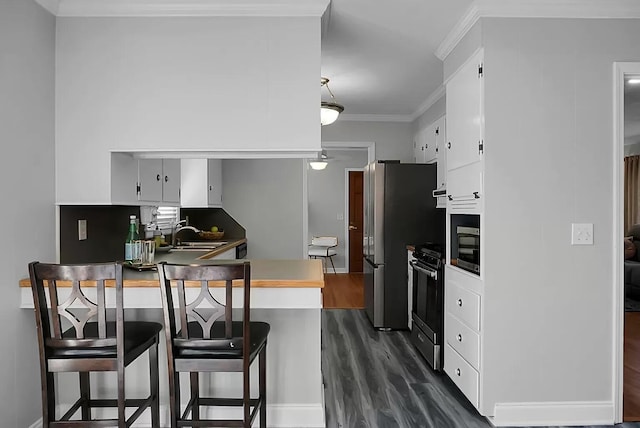 1113 Smithfield Pl, Hanahan, SC 29410 - kitchen with crown molding, dark wood-type flooring, white cabinets, a sink, and stainless steel appliances