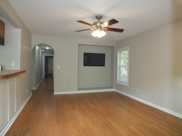418 Meritta Ave, Beaufort, SC 29902 - unfurnished living room featuring arched walkways, light wood-style flooring, ceiling fan, and baseboards