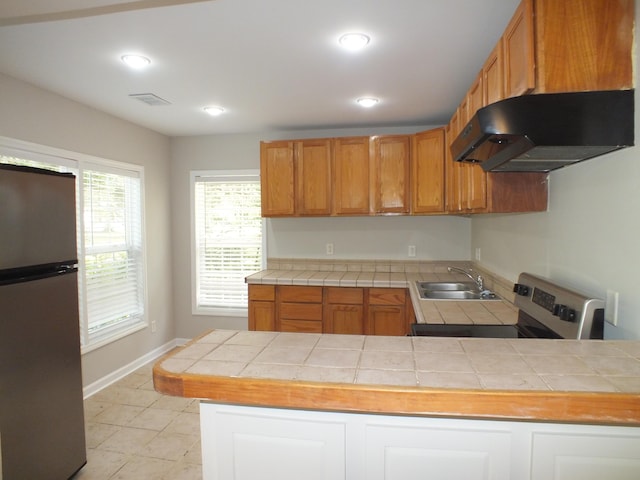 418 Meritta Ave, Beaufort, SC 29902 - kitchen featuring stainless steel appliances, a sink, under cabinet range hood, tile counters, and baseboards