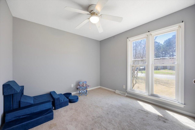 living area featuring visible vents, ceiling fan, baseboards, and carpet