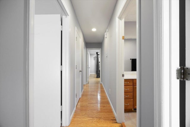 hall with baseboards and light wood-type flooring