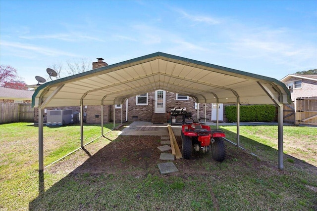 view of vehicle parking with a carport and fence