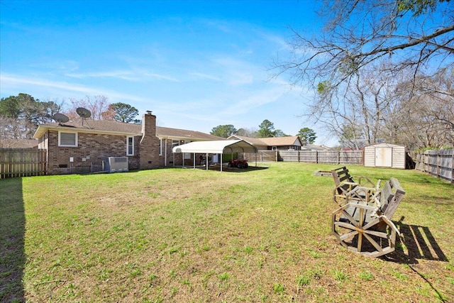 view of yard featuring a fenced backyard, a storage shed, an outdoor structure, a carport, and central AC unit