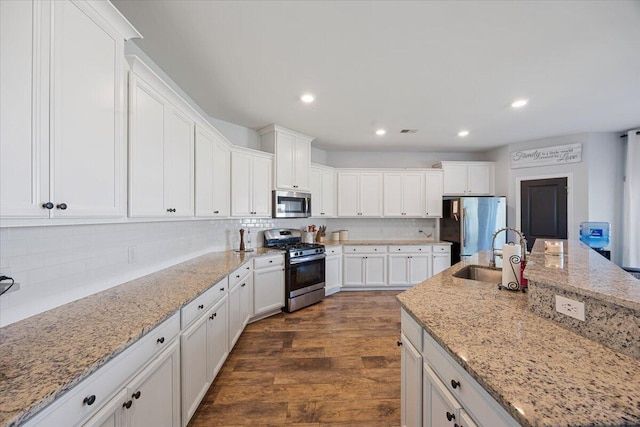 707 Redbud Ln, Summerville, SC 29486 - kitchen featuring stainless steel appliances, decorative backsplash, dark wood finished floors, a sink, and white cabinets
