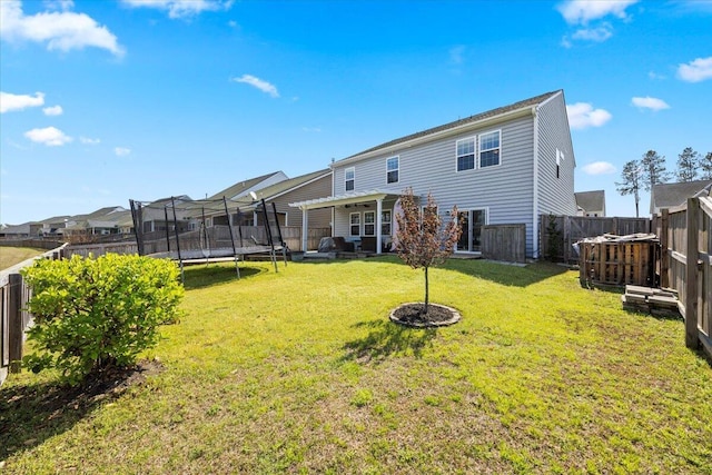 707 Redbud Ln, Summerville, SC 29486 - rear view of house with a trampoline, a fenced backyard, a yard, and a residential view
