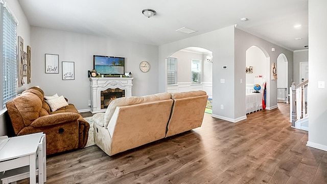 5138 Preserve Blvd, Ladson, SC 29456 - living area featuring arched walkways, a warm lit fireplace, wood finished floors, crown molding, and baseboards