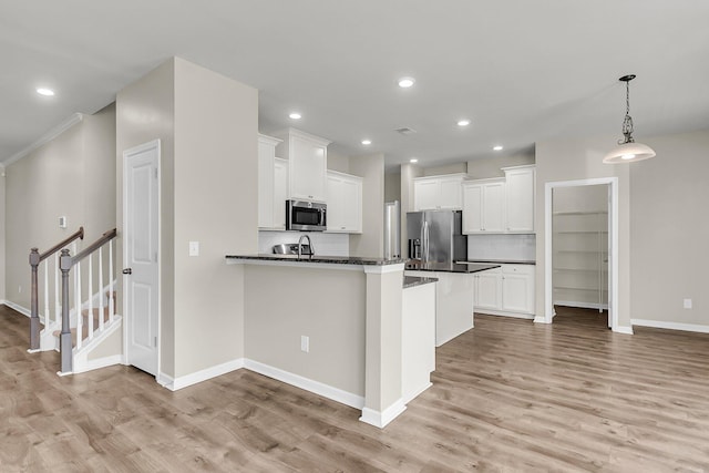 5138 Preserve Blvd, Ladson, SC 29456 - kitchen featuring appliances with stainless steel finishes, dark countertops, light wood-style flooring, white cabinetry, and baseboards