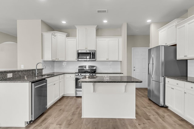 5138 Preserve Blvd, Ladson, SC 29456 - kitchen featuring stainless steel appliances, a sink, dark stone counters, arched walkways, and decorative backsplash
