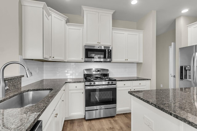5138 Preserve Blvd, Ladson, SC 29456 - kitchen featuring appliances with stainless steel finishes, a sink, white cabinetry, dark stone countertops, and tasteful backsplash