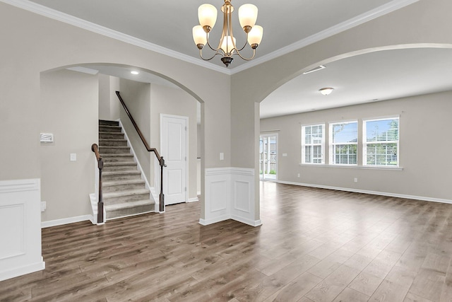 5138 Preserve Blvd, Ladson, SC 29456 - spare room featuring wood finished floors, arched walkways, a chandelier, ornamental molding, and stairway