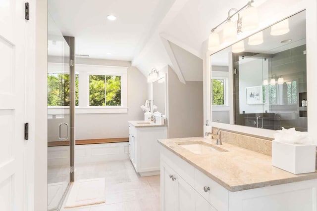 full bath with two vanities, a shower stall, and a sink