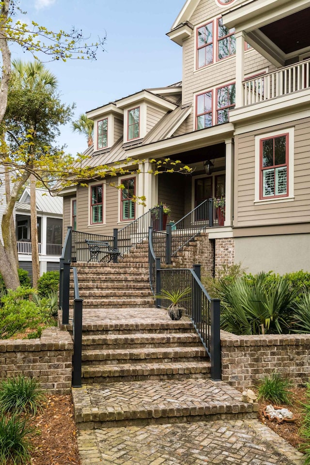 view of front of home with stairway and a porch