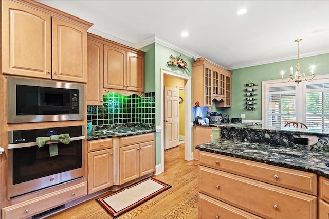 kitchen featuring stainless steel oven, built in microwave, a chandelier, glass insert cabinets, and ornamental molding