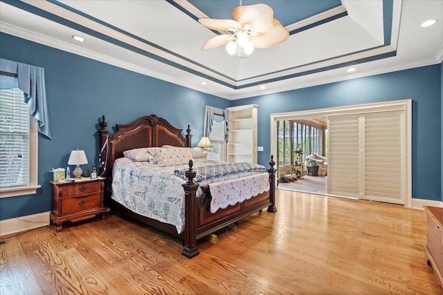 bedroom featuring wood finished floors, crown molding, access to exterior, a ceiling fan, and a raised ceiling