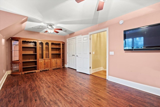unfurnished bedroom with dark wood-style floors, baseboards, ceiling fan, and vaulted ceiling