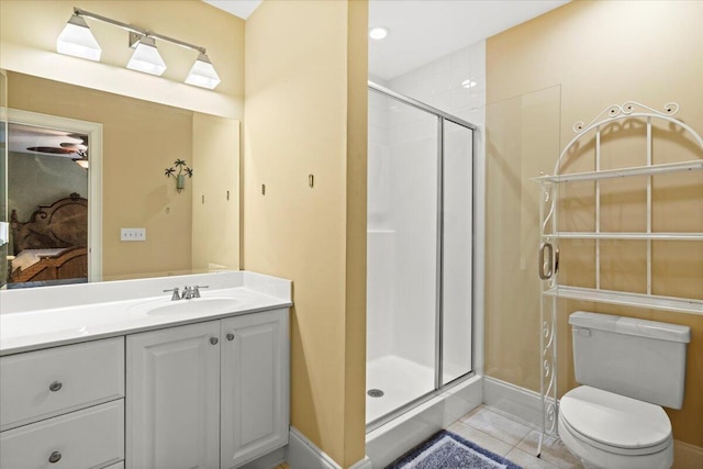 bathroom featuring a shower stall, vanity, tile patterned floors, toilet, and baseboards